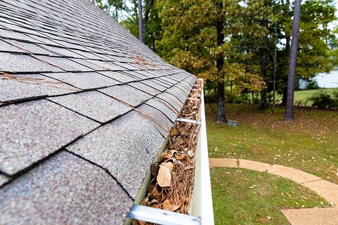 clearing debris from clogged gutters